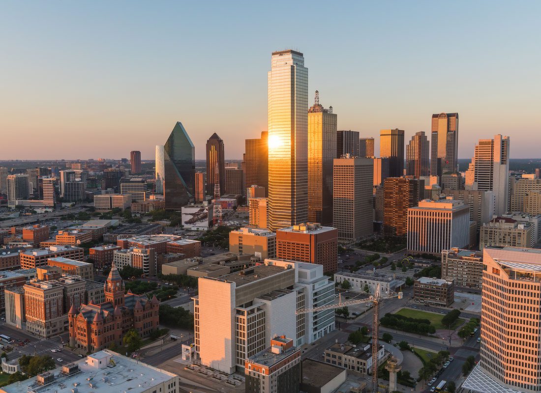 Dallas, TX - Aerial View of Downtown Dallas Texas Commercial Buildings Against a Clear Sky at Sunset
